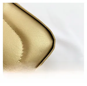Detail shot of golden faux leather handbag featuring premium pebble grain and fine stitching