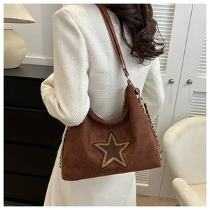 Close-up of brown suede hobo bag featuring a large star embroidery and elegant metal chain