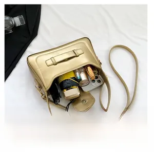 Internal view showing champagne gold handbag capacity with phone and umbrella