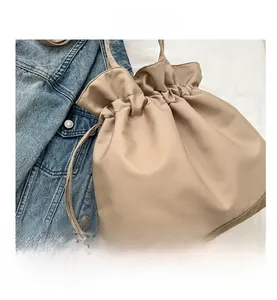 Detail der khakifarbenen Kordelzug-Beuteltasche mit Leder- und Canvas-Patchwork