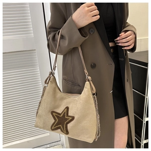 Detailansicht beige Wildleder-Unterarmtasche mit braunem Sternstick und Metallkettenriemen