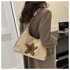 Detail of khaki suede hobo bag with brown star patch and leather chain strap