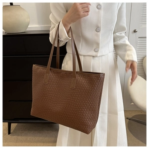 Gros plan d'un grand sac cabas vintage marron avec texture tressée et style élégant