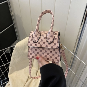 Pink mini crossbody bag with dark brown clover pattern and detachable shoulder strap