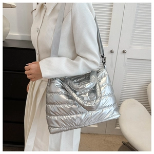 Detail of silver quilted puffer tote bag with wide strap for winter fashion look