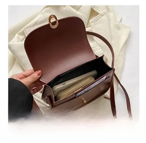 Vue intérieure d'un sac besace marron montrant l'espace pour téléphone et portefeuille