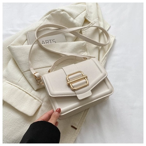 Close-up of cream rectangular flap bag with grainy leather and gold H-buckle detail