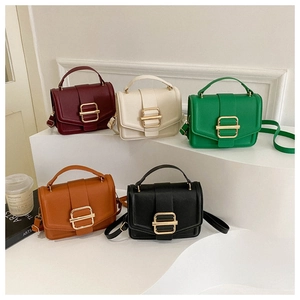 Close-up of stylish textured leather handbags in five colors with gold square clasps