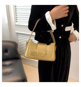 Detail shot of champagne gold leather shoulder bag with embossed strap and buckle