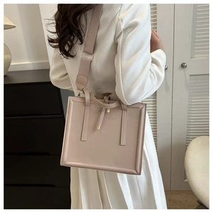 Sac fourre-tout beige minimaliste porté par un modèle dans un intérieur moderne