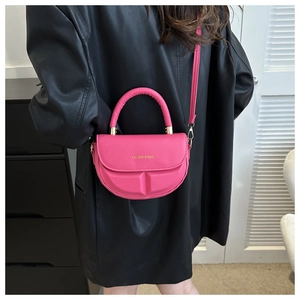 Detail of rose pink saddle bag featuring 3D embossed texture and gold metal hardware