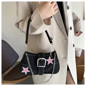 Dettaglio borsa sottobraccio in tela nera con stelle rosa e fibbia argentata elegante
