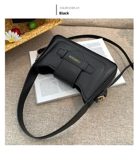 Close-up of black leather shoulder bag with golden buckle and refined brand lettering