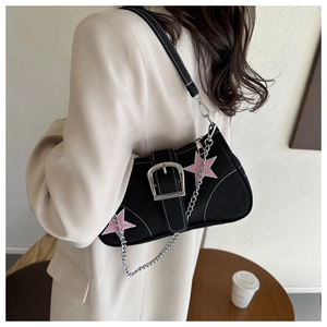 Dettaglio della borsa sottobraccio in tela nera con patch a stella rosa e catena d'argento
