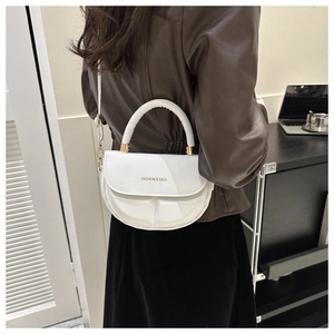 Detail of white minimalist crossbody bag showing pleated base and gold lettering
