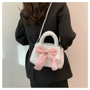 Dettaglio borsa di peluche bianca con fiocco di raso rosa e tracolla di perle eleganti