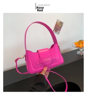Detail of rose red PU leather shoulder bag with brand logo and minimalist strap