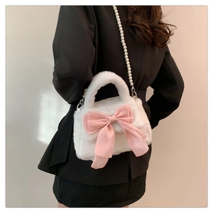 Dettaglio borsa a tracolla in peluche bianca con fiocco in raso rosa e cinturino di perle