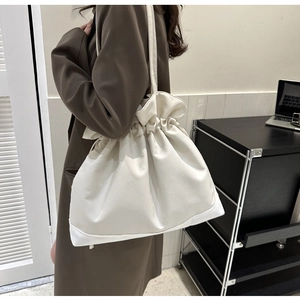 Detail einer minimalistischen cremeweißen Kordelzugtasche mit hochwertiger Naht und Textur