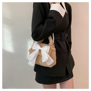 Borsa a tracolla in peluche marrone con grande fiocco bianco e manico di perle