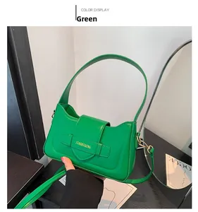 Detail view of a vibrant green half-moon underarm bag with gold branding and crossbody strap
