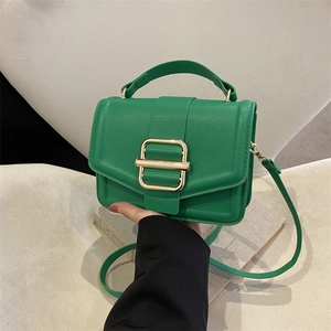 Chic green lychee leather handbag with a bold gold buckle and versatile crossbody strap