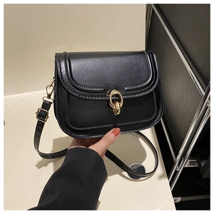 Détail du sac à bandoulière en cuir noir avec une élégante boucle dorée à double anneau