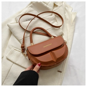 Close-up of brown PU leather saddle bag with geometric texture and metal handle