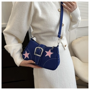 Dettaglio della borsa a spalla in tela blu con stelle rosa e grande fibbia argentata