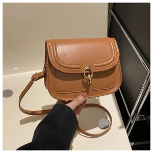 Détail d'un sac bandoulière en cuir PU marron avec boucle métallique dorée ronde