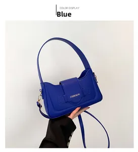Blue faux leather baguette bag detail with metal buckle and adjustable shoulder strap