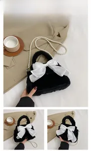 Détail d'un sac en peluche noir avec un nœud en satin blanc et une bandoulière perlée