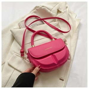 Detailed view of magenta PU saddle bag with 3D geometric texture and gold hardware