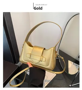 Close-up of golden metallic underarm bag featuring buckle detail and fashion embossing