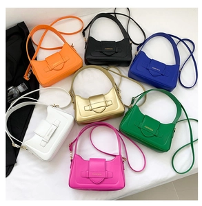 Detail view of colorful glossy faux leather underarm bags in multiple vibrant colors