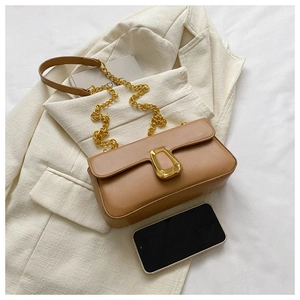 Detail of caramel faux leather bag featuring a gold geometric buckle and chain strap