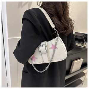 Dettaglio borsa in tela crema con patch a stella rosa e catena argento indossata