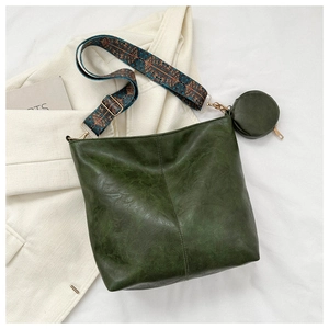 Detail of dark green vintage bucket bag with ethnic strap and small round coin purse