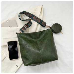 Detail of dark green vintage crossbody bag with a bohemian strap and a round coin pouch