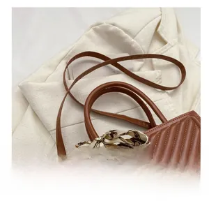 Detail of dark brown quilted shoulder bag with chain pattern silk scarf and thin strap
