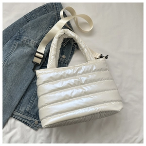 Detailed view of white quilted down tote bag with adjustable strap and pearly texture