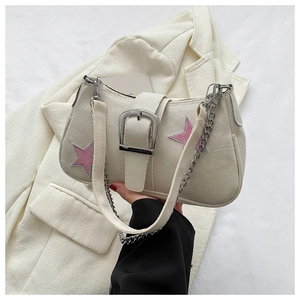 Dettaglio della borsa a spalla in tessuto bianco con stelle ricamate rosa e fibbia argento