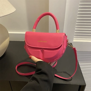 Rose pink leather saddle bag with gold lettering and adjustable crossbody strap