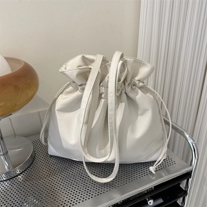 Große weiße Kordelzug-Tragetasche aus Nylon auf einem industriellen Metallregal platziert