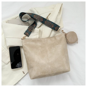 Creamy white crossbody bag with vintage patterned wide strap and small coin pouch detail