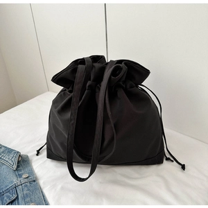 Detail shot of black drawstring tote bag with contrast stitching and wide shoulder straps