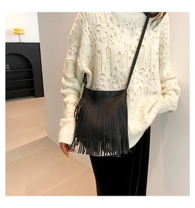 Detail of black pebbled leather crossbody bag with long fringe tassels for women