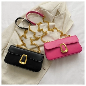 Detail of minimalist chain square bags in black and rose pink with gold trapezoid clasps