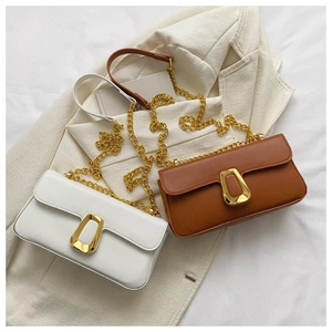 Detailed shot of white and brown flap bags with gold geometric hardware and chain straps