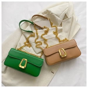 Detail view of stylish green and brown flap bags with gold geometric buckles and chain straps